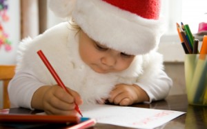 The small child writes the letter to Santa
