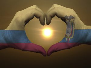 Heart and love gesture by hands colored in ecuador flag during b