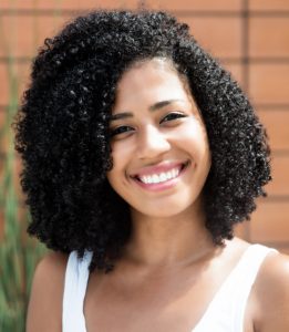 Portrait of a laughing latin woman with curly black hair