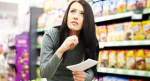 Una-chica-comprueba-la-lista-de-la-compra-en-el-supermercado