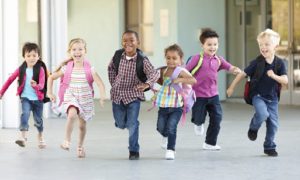 Group Of Elementary Age Schoolchildren Running Outside