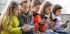 Niños en la calle con móvil