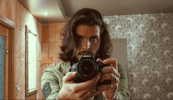 Fredi Leis posa en un espejo con una cámara