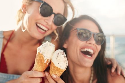dos amigas sonríen con un helado en la mano