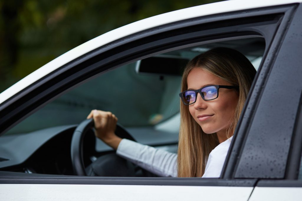 Chica con gafas conduciendo un coche