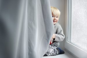 Niño travieso pequeño escondido