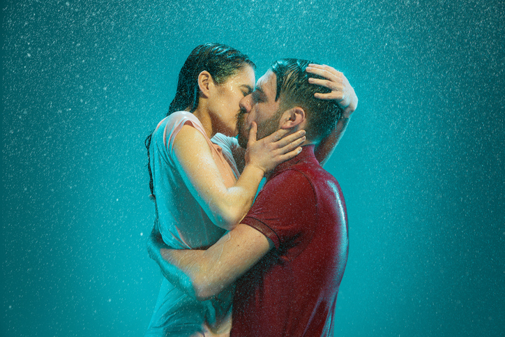 pareja se besa bajo al lluvia