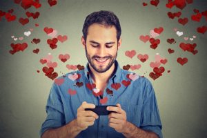 man sending love sms message on mobile phone