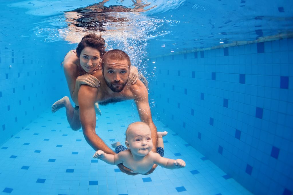 Familia buceando en una piscina