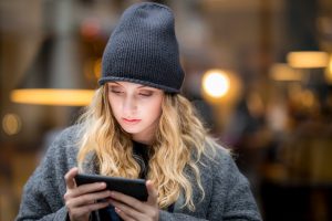 Portrait of serious young woman using smartphone