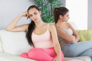 dos-mujeres-molestas-sentadas-en-un-sofa_13339-13201