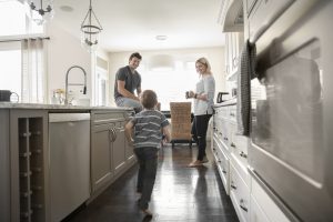 Parents watching son running in kitchen