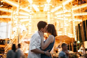 Couple kissing near the marry-go-round in the park
