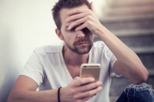 Man Using Mobile Phone While Sitting On Stairs