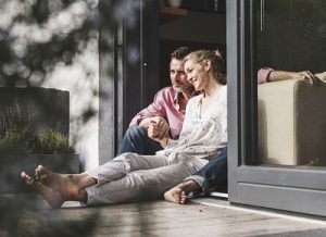 Content mature couple relaxing together at open terrace door