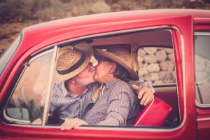 Senior Couple Kissing In Vintage Car