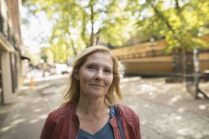 Portrait smiling mature woman on urban sidewalk