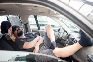 Man sleeping in car during travel