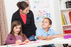 Art teacher helps students in class