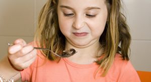 Cara de asco de una niña al comer