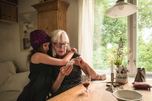 Una abuela trastea con el móvil junto a su nieta