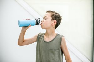 niño bebe agua de botella