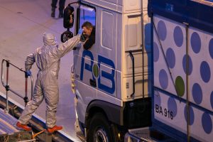 A man dressed in a protective suite measures the body