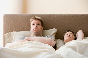 Frustrated man and sleeping woman
