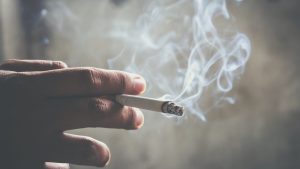 Una mano sosteniendo un cigarro fumar