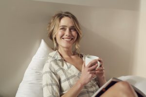 mujer toma cafe cama pijama