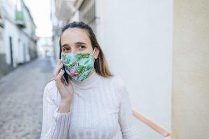 Woman with protective mask talking on the phone