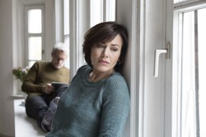 Disappointed woman with man in background