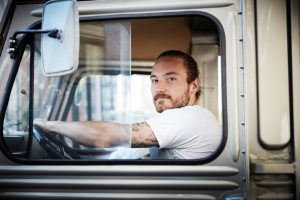 Portrait of young man driving food truck in city