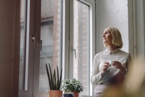 Mature businesswoman having a coffee break at the window in office