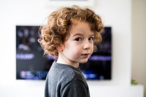 niño se gira mirando la televisión