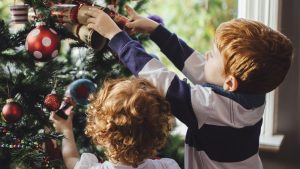 niños colocan árbol de Navidad