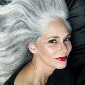 Glamorous portrait of a woman with long gray hair.