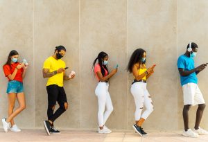 Young people group with face mask waiting to get in the supermarket. Coronavirus and spread virus prevention concept. Image