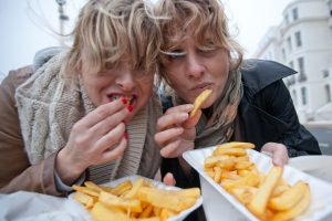 dos chicas comen patatas