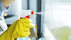 Young woman washing window