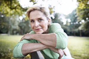 Portrait of confident mature woman sitting on a park bench