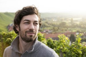 Germany, Bavaria, Volkach, portrait of winegrower in vineyard