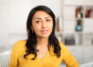 Portrait of  Latin American woman in casual clothes on  light office background