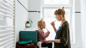 Mamá y niña lavándose los dientes