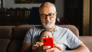 hombre y bebé con teléfono padre
