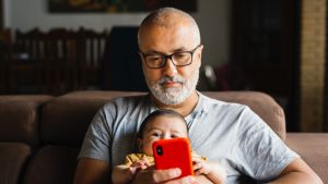 hombre y bebé con teléfono padre