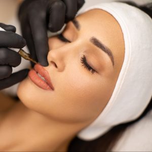 Beautiful young woman receiving permanent make up