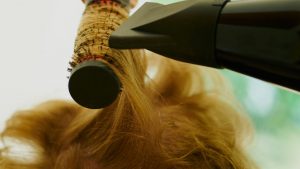 Side view human hair drying hair brushing beauty treatment blond and straight hair