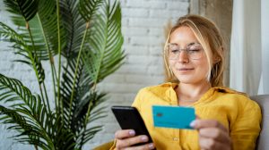 mujer con la tarjeta de crédito y el móvil bizum