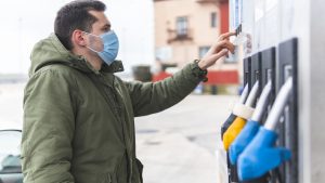 Man in protective face mask at gas station during COVID-19